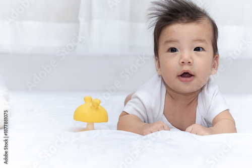 Wallpaper Mural Cute Asian little boy is lying on the bed, looking and smiling happily. A lovely Asian babe lay in bed playing, watching and then laughing happily. Torontodigital.ca