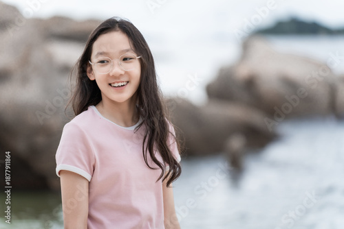 Girl wearing glasses gazing at the beach