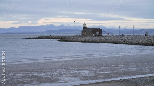 4K: The Stone Jetty in Morecambe on a cold, grey day. The Lake District fells are behind with snow on. Stock Video Clip Footage.