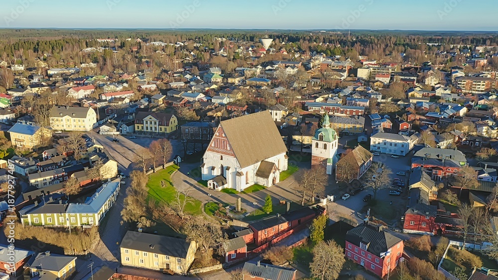 Obraz premium Porvoo, Finland - December 08, 2020: Aerial perspective of a picturesque town featuring a historic church surrounded by colorful buildings and lush greenery, showcasing urban beauty