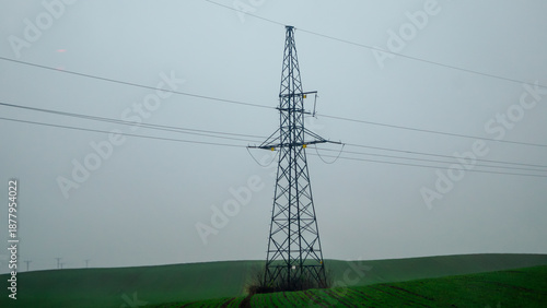 High-voltage transmission line in the middle of a field on a cloudy day