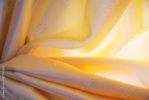 Primer plano de tela de satén naranja con pliegues suaves, reflejos brillantes y textura fluida.sensualidad y movimiento, simbolizando elegancia, suavidad y expresividad textil.