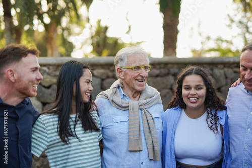 Photos Group of multiracial people with different ages hugging each other outdoor with