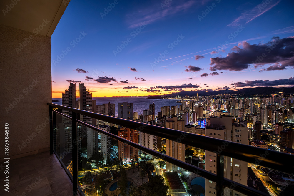 © yaqui_villegas - benidorm spain mediterranean balcony terrace overlooking skyline cityscape at twilight as lights appear along the horizon above the sea