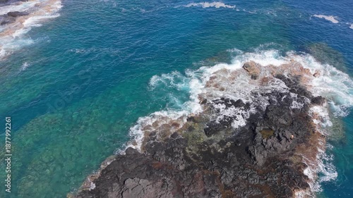 Aerial drone footage showing a lone fisherman actively casting his fishing line while standing on volcanic rocks along the coastline in Cap La Houssaye Reunion Island. Ideal for fishing activities.