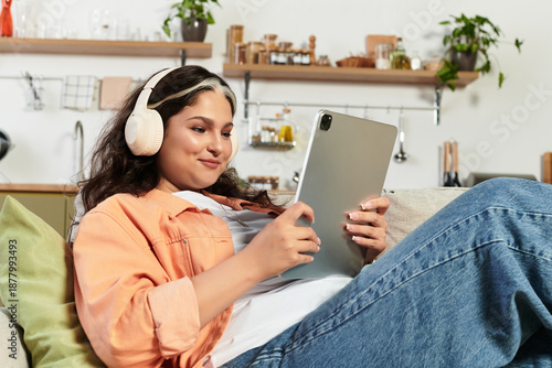 A woman enjoys her tablet at home, showcasing her white forelock and vibrant personality.
