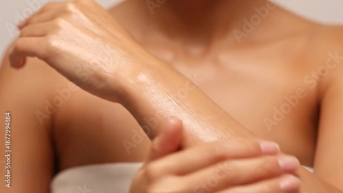 Woman applying lotion to her arm for smooth skin