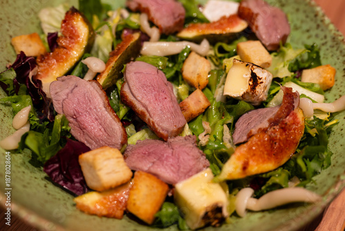 green salad with tender and succulent medium rare duck breast figs and croutons - hearty and elegant wholesome dinner