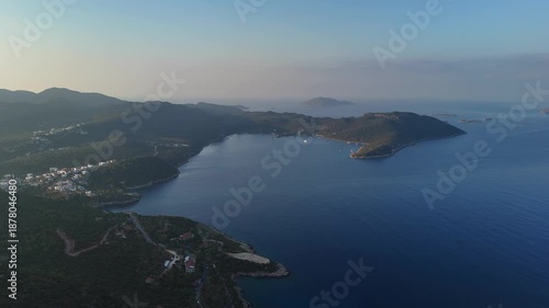 Aerial view of calm coastal bay with islands, green hills and deep blue sea. Natural seascape, summer travel destination and peaceful Mediterranean coastline.