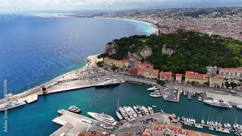 Aerial view of Nice harbor with yachts, marina, turquoise sea and colorful buildings. Scenic French Riviera coastline and Mediterranean city landscape.