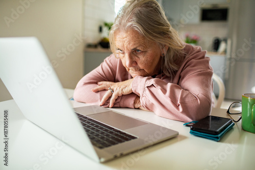 Fotografija Senior woman struggling with laptop at home kitchen