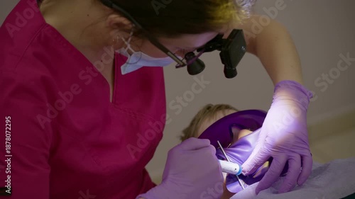 A dentist works meticulously on a childs teeth, surrounded by bright colors and soft lighting.