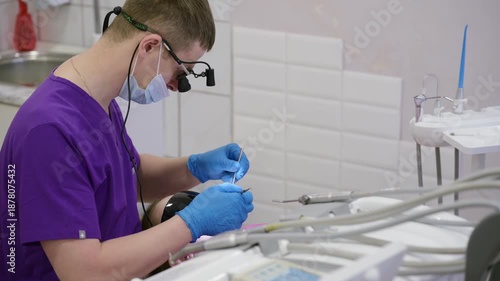A skilled dentist wears protective gear while carefully treating a patient in a bright, modern clinic. The slow motion highlights the dedication to dental health and safety.