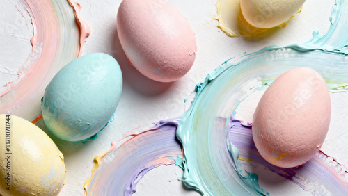 Colorful Easter eggs arranged on a white surface with paint strokes  