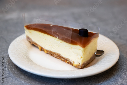 Fotografia Artfully arranged caramel cheesecake on pristine white plate with chocolate deta