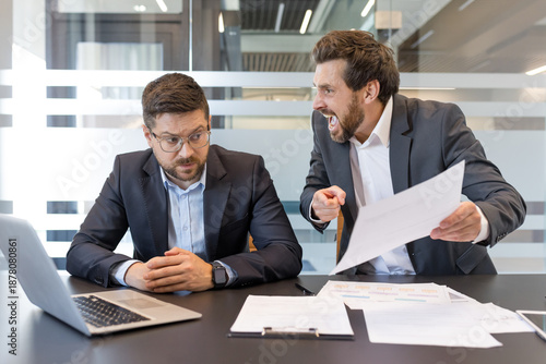 Slika na platnu Male executive aggressively berating an overwhelmed subordinate at a cluttered d