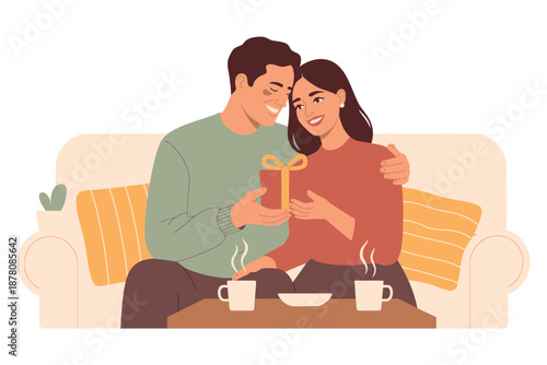 A happy couple sitting on a couch, exchanging gifts and enjoying a romantic evening together.