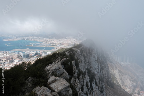 Gibraltar city and harbor visible from above, with the rock of gibraltar peak partially hidden in dense fog