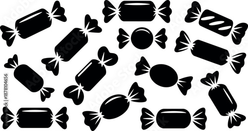 A collection of black and white candy wrappers in various shapes and sizes scattered across a clean isolated background representing a sweet treat concept