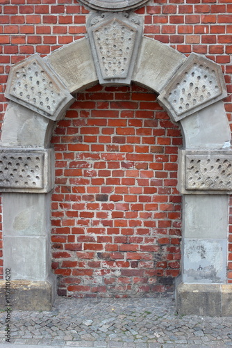 Bricked up stone arch in historic brick wall