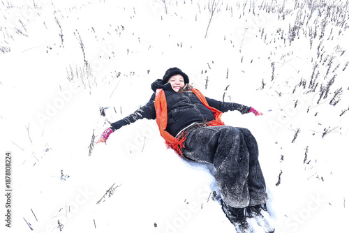 A thirteen-year-old girl in black lies in the snow during a winter walk