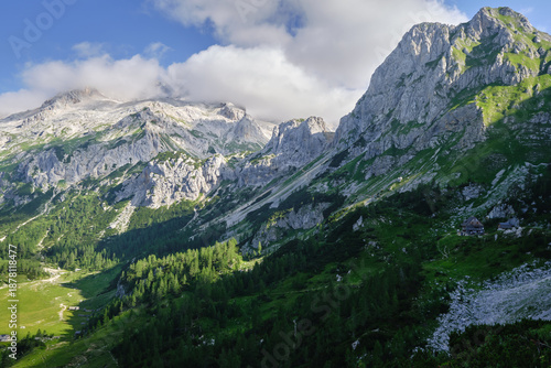 Stunning view of Triglav mountain range with sharp mountain ridges, cloudy sky and great light