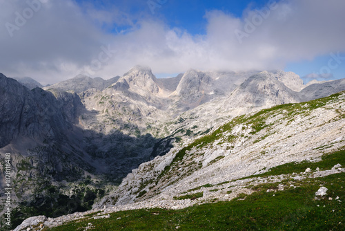 Stunning, misty view of Triglav mountain range with sharp mountain ridges under a cloudy sky