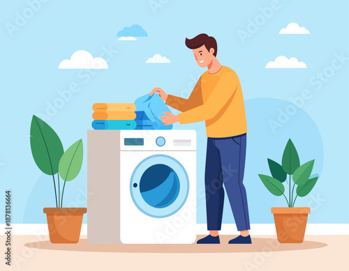A young man does his laundry at home, putting clean clothes into a modern washing machine. This scene represents daily household chores and domestic life.