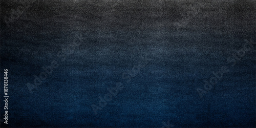 A closeup surface of dark blue denim fabric reveals a textured cotton material pattern, creating a rough grunge textile backdrop for fashion clothing and jeans