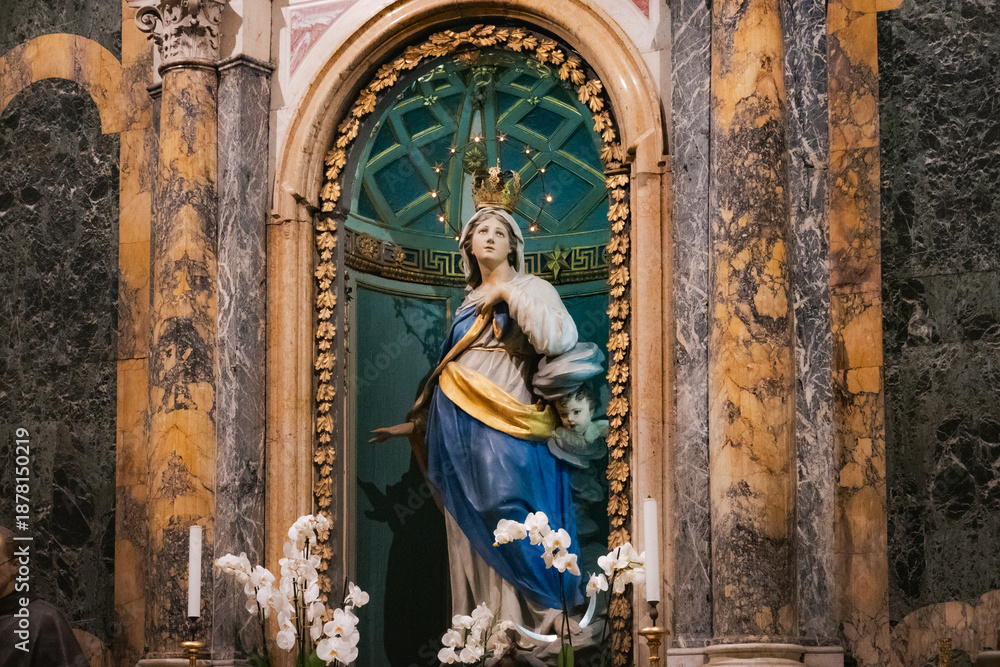Obraz premium Historic Baroque statue of the Immaculate Conception inside the Basilica di San Francesco in Ravenna, Italy. The marble monument features a blue and gold niche background.