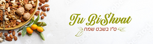 Mix of dry fruits and nuts, branch with young green leaves. Concept of the Jewish holiday Tu Bishvat