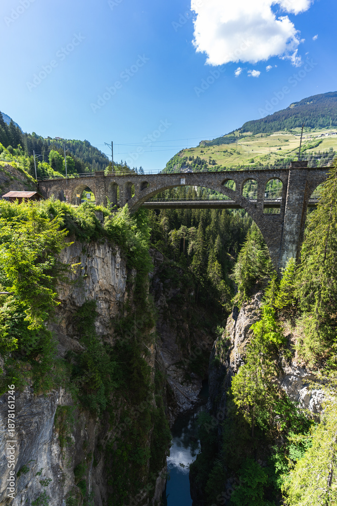 Fototapeta premium Historic Viaduct Spans Deep Gorge in Swiss Alps