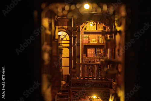 Canvas Print Magical wooden book nook miniature library diorama glowing with warm lights in the dark