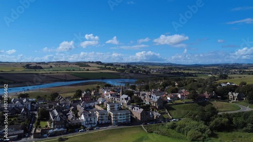 Aerial drone view of the village of Alnmouth in Northumberland showing buildings and roads along the river Aln and surrounding countryside