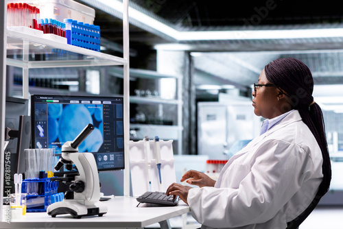 Wallpaper Mural Black female chemistry expert opening laboratory software on pc and reviewing experiment data, studying the matter for genetics research. Laboratory testing with biotechnology equipment. Torontodigital.ca