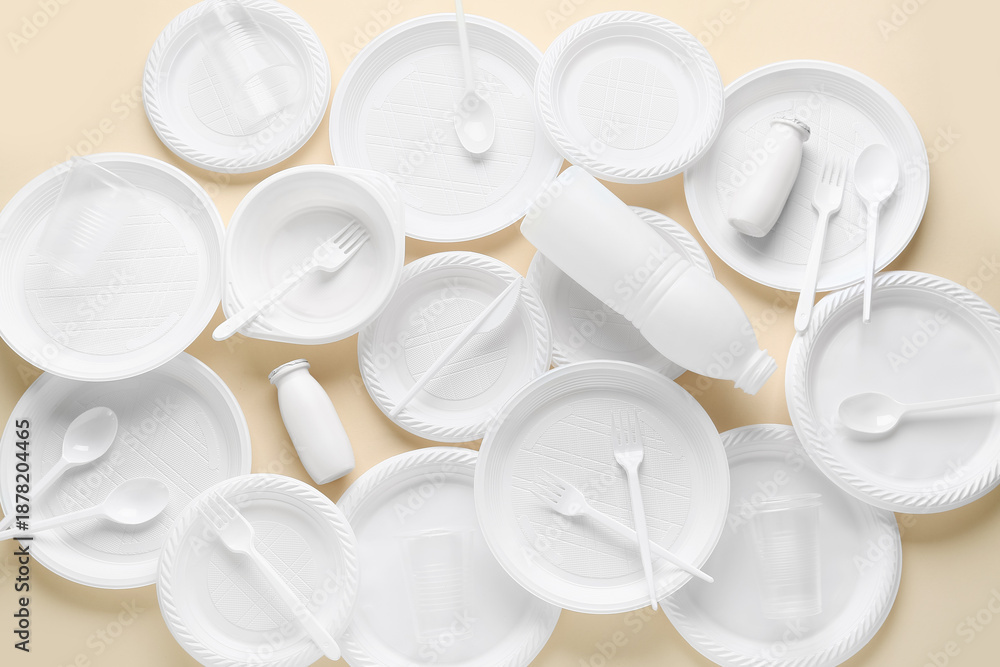 Fototapeta premium Different white plastic tableware on beige background