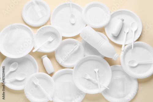 Different white plastic tableware on beige background © Pixel-Shot