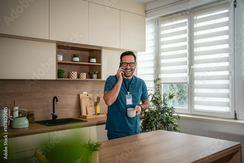 Foto Male healthcare worker smiling during phone call break