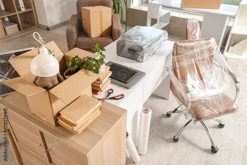 Cuadro en lienzo Interior of office with desk, boxes and wrapped chairs in stretch film on moving