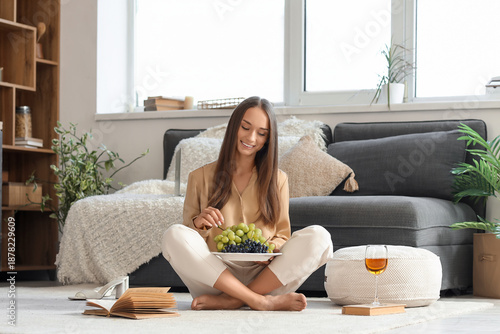 Young woman with grapes sit...