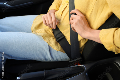 Young woman fastening seat ...