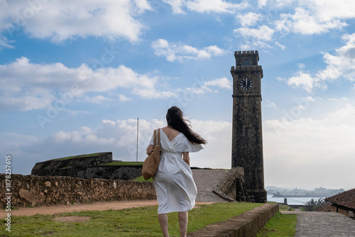 Foto A young woman stands in front of the clock tower at Galle Fort, Sri Lanka