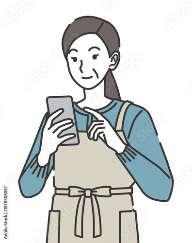 スマホを見るエプロン姿の主婦