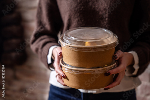 Woman offering stacked eco takeaway meals