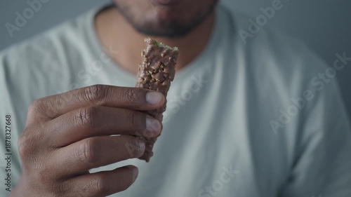 Man eats snack while sitting in a simple space