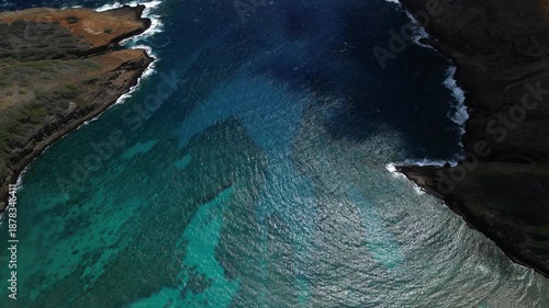 Aerial drone view of hanauma bay ocean channel between volcanic cliffs with deep blue pacific water in honolulu hawaii
