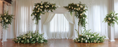 Wedding arch white curtain floral decoration ceremony backdrop green foliage wooden floor indoor venue romantic flower arrangement aisle wedding