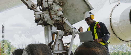 Mechanics inspect the engines of a large plane before takeoff at a summer airport.(PHOTO)