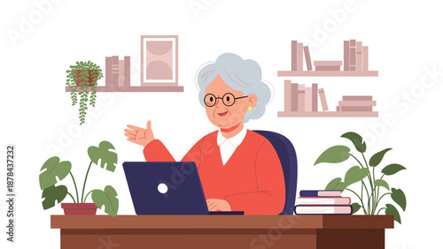 Cheerful senior woman with grey hair sitting at a wooden desk with a laptop in a cozy home office with houseplants and books.