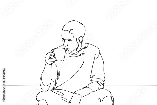Man is sitting on the floor and drinking a cup of coffee. The image has a calm and relaxed mood, as the man is enjoying his coffee in a quiet setting